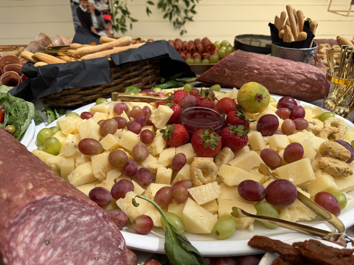 Cheeses, grapes, cured meats and bread arranged for a catered reception